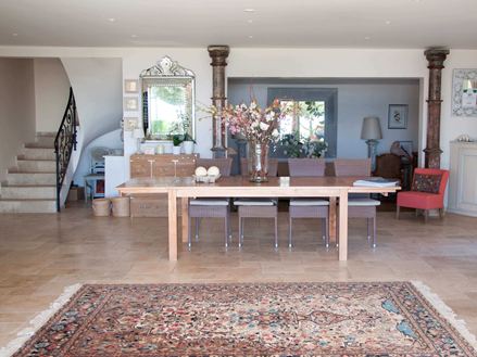 Ingresso di un hotel con tappeto persiano e tavolo in legno su piastrelle di travertino