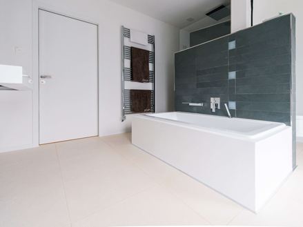 Bagno con vasca e piastrelle in pietra calcarea Miros, spazzolato