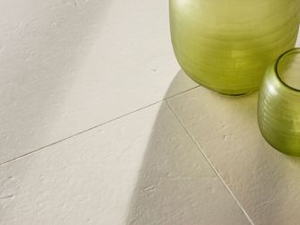 Piastrelle in pietra calcarea spazzolata Miros con due vasi decorativi verdi