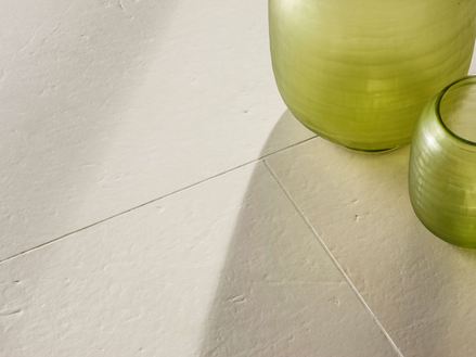 Piastrelle in pietra calcarea spazzolata Miros con due vasi decorativi verdi