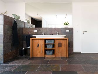 Piastrelle in ardesia color pavone in un bagno moderno-rustico