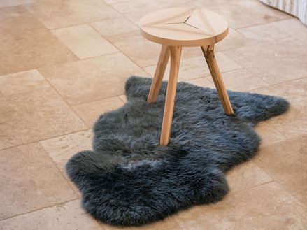 Piastrella in travertino con sgabello a tre gambe in legno