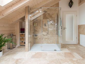 Piastrelle rustiche in travertino nel bagno con doccia