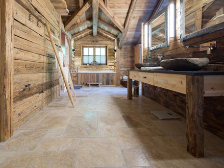 Bagno benessere con legno e piastrelle in travertino rustico
