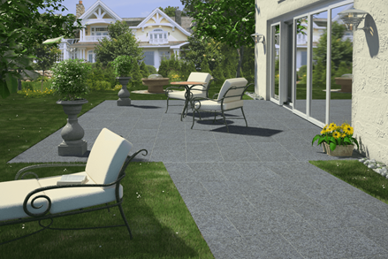 Terrazza con lastre di basalto e arredi moderni, giardino verde a sinistra