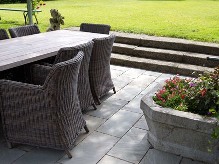 Mobili in rattan su lastre di arenaria grigia