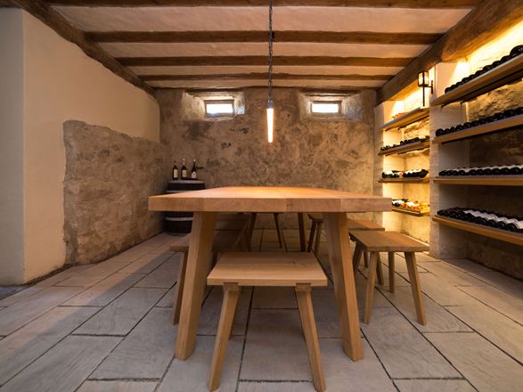 Cantina con mobili rustici in legno, scaffali per il vino e pavimento in pietra arenaria grigia