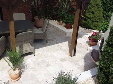 Lastre di travertino Medium, terrazza con sedute in rattan