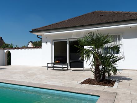Terrazza mediterranea in travertino con pollice e palma
