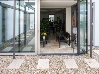 Vista dalla terrazza di Travertin Rustic all'elegante giardino d'inverno