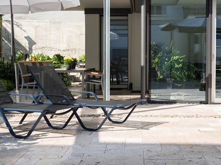 Elegante cortile con travertino e splendida area prendisole