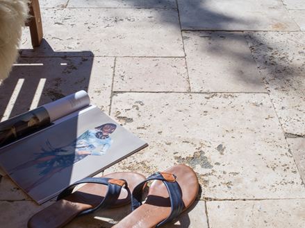 Rivista e scarpe su terrazza in travertino Rustic