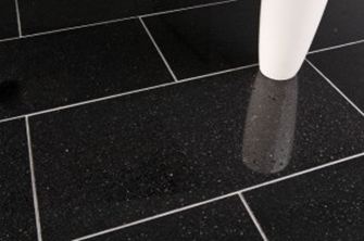 Un vaso bianco su piastrelle di granito nero con fughe chiare