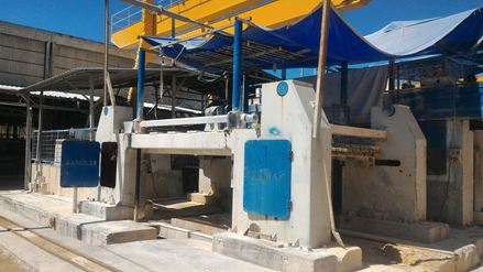 Una sega a nastro taglia un blocco di pietra grezzo in cosiddette "fette".