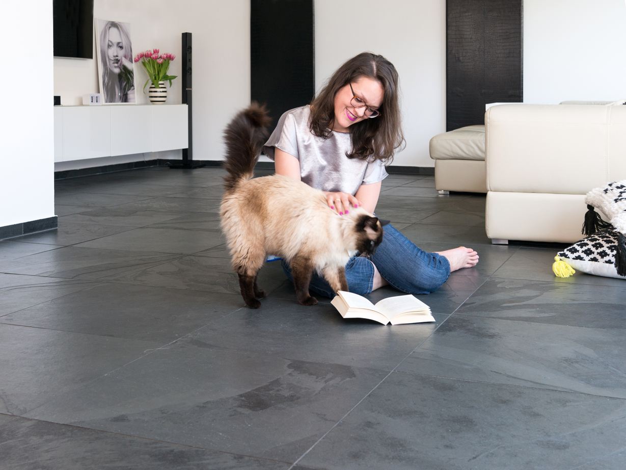 Donna e gatto su piastrelle di ardesia Mustang