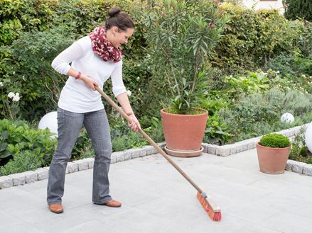 Donna pulisce la terrazza grigia di Granit Mundo