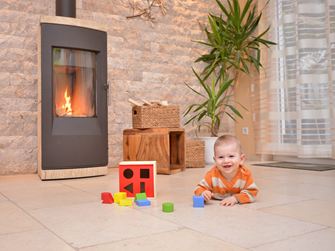 Il bambino gioca su un pavimento in pietra naturale davanti a un camino