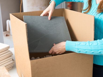 Un dipendente confeziona un campione di pietra naturale in una scatola