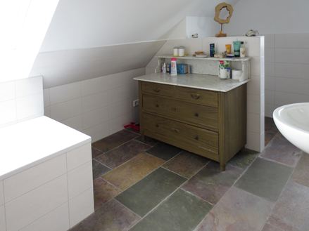 L'ardesia colorata del bagno si integra meravigliosamente con gli interni bianchi.