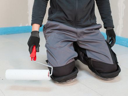 Il piastrellista applica il primer sul massetto