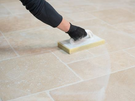 Le fughe vengono lavate via dalle piastrelle di travertino posate con una tavola di spugna