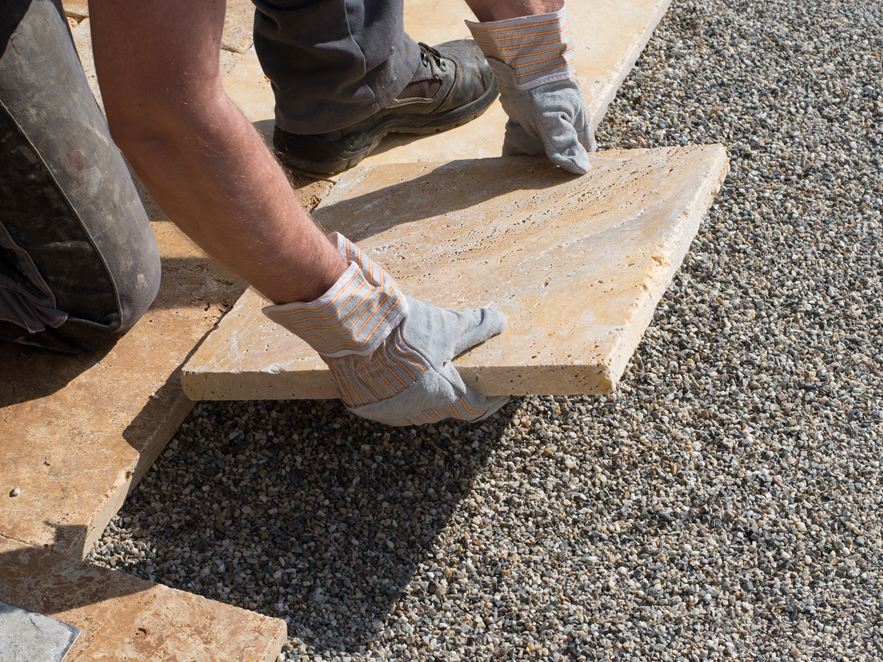 Posa di lastre per patio in pietra naturale in un letto di graniglia