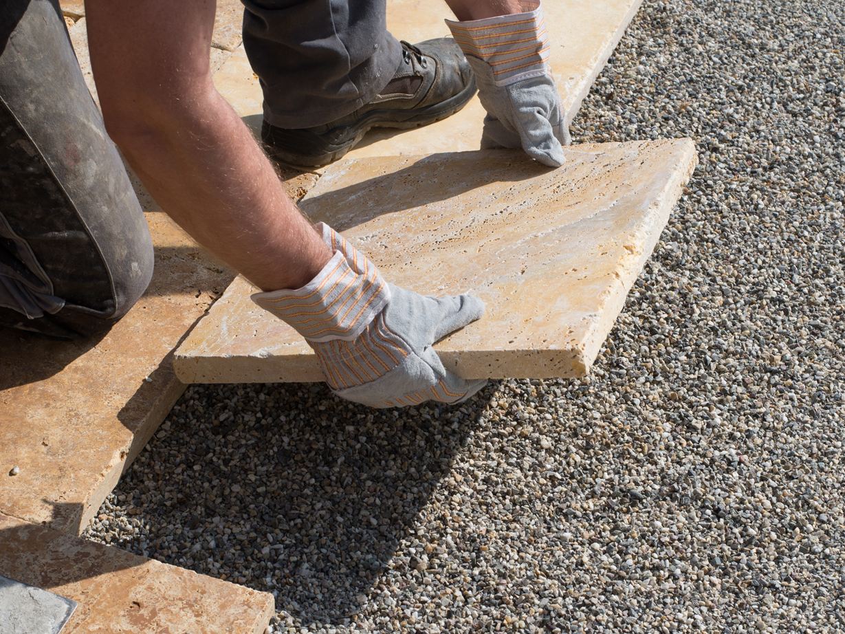 Posa di lastre per patio in pietra naturale in un letto di graniglia