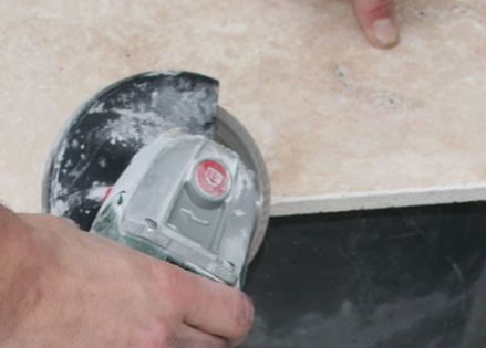 Una lastra di pietra viene segata con una fresa ad angolo